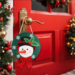 Close-up of a festive wooden snowman welcome sign hanging on a vibrant red door handle