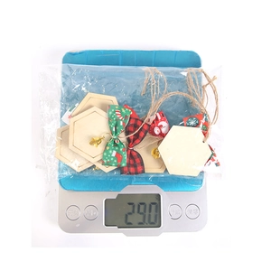 Christmas bow wooden hanging tags on a scale showing 29g weight for DIY holiday decor