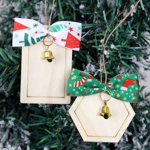 Close-up of wooden Christmas tags with festive bows and tiny bells on a tree branch