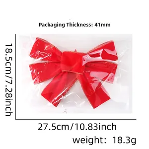 Detail of red velvet Christmas bow with gold edges in transparent packaging