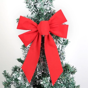 Close-up of 23cm red velvet Christmas bow with wired edges on a snowy pine branch