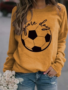Close-up of Game Day slogan and football print on mustard yellow crewneck sweatshirt