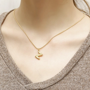 Minimalist gold titanium necklace featuring a bamboo-style initial Z pendant on a sleek chain