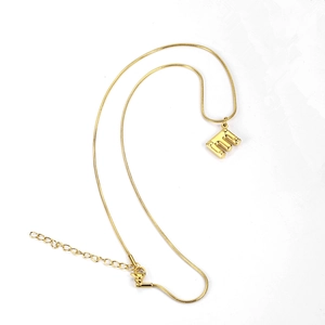 Detail of gold snake chain necklace featuring letter E pendant and lobster clasp closure