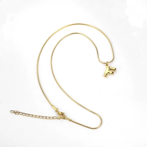 Detailed close-up of golden letter F pendant on a sleek snake chain necklace