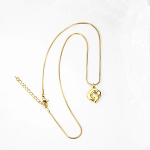 Detail of gold initial G pendant necklace with sleek snake chain and lobster clasp