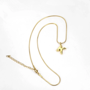 Detailed shot of golden snake chain featuring an intricate engraved capital letter K pendant