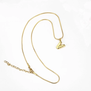 Detailed view of golden 3D letter V pendant with star patterns on a snake chain