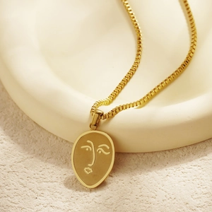 Collier en acier titane plaqué or 18k avec pendentif visage abstrait sur céramique blanche