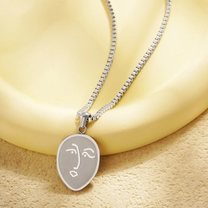 Collier minimaliste argenté avec pendentif visage abstrait et chaîne en acier