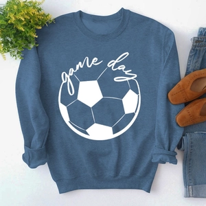 Flat lay of navy blue Game Day sweatshirt with soccer graphic and casual accessories