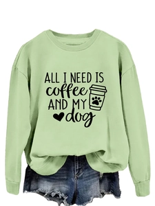 Detail view of the sage green sweatshirt featuring 'ALL I NEED' print and coffee graphics