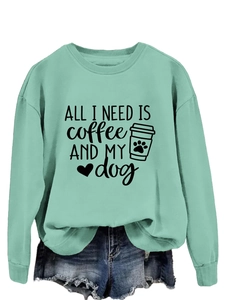 Close-up of mint green sweatshirt featuring ALL I NEED IS coffee AND MY dog print