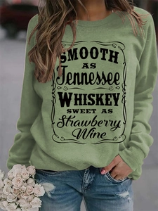 Detail of sage green sweatshirt featuring black text print and ribbed sleeve cuffs
