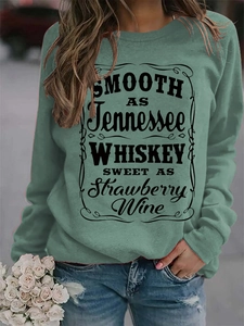 Detail of greyish-green crewneck sweatshirt featuring retro black whiskey lyrics print