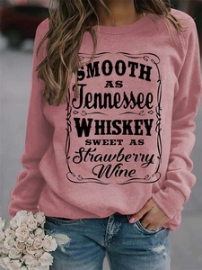 Detail of pink crewneck sweatshirt with Tennessee Whiskey black letter print graphics