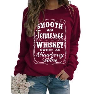 Close-up of vintage white lettering on burgundy crewneck sweatshirt with blue jeans
