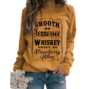 Detail of female model in ginger yellow sweatshirt with vintage letter print and denim