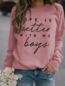 Detail of LIFE IS Better text print on pink crewneck sweatshirt with ribbed cuffs