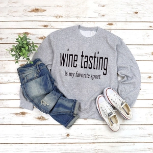 Flat lay of gray Wine Tasting slogan sweatshirt with casual blue jeans and white shoes