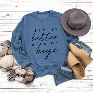 Close-up of blue crewneck sweatshirt with Life Is Better With My Boys print and autumn decor