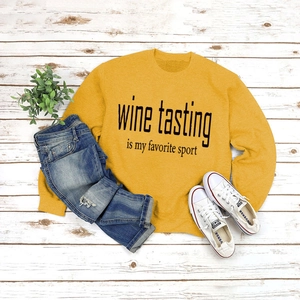 Flat lay of yellow Wine Tasting sweatshirt styled with blue jeans and white sneakers