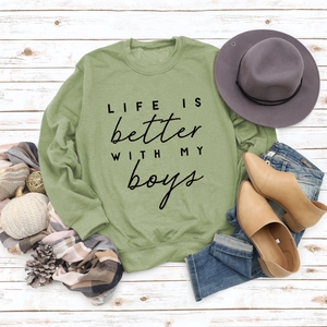 Sage green crewneck sweatshirt with LIFE IS BETTER text and casual accessories