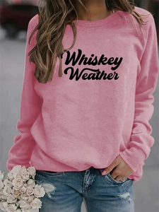 Pink crewneck sweatshirt with Whiskey Weather text print worn by model holding roses
