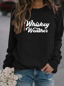 Detail of Whiskey Weather lettering on black crewneck sweatshirt with casual denim jeans