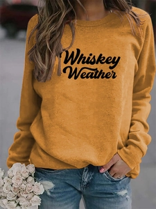 Detail of Whiskey Weather lettering on mustard yellow crewneck long sleeve sweatshirt