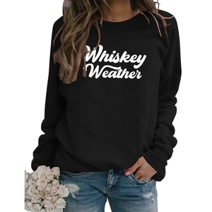 Close-up of Whiskey Weather script lettering on a black crewneck sweatshirt with flowers