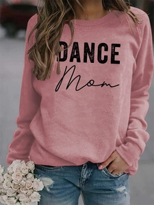 Detail of pink crewneck sweatshirt featuring black DANCE MOM letter print and soft fabric