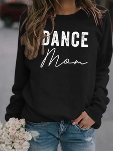 Detail of white DANCE MOM print on a casual black crewneck sweatshirt with cotton texture