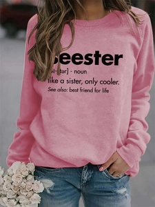 Detailed close-up of the black dictionary print on a pink crewneck long-sleeve sweatshirt
