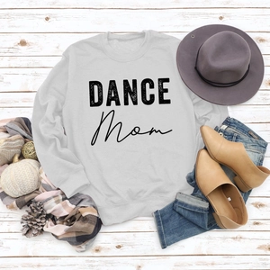 Flat lay of gray DANCE MOM sweatshirt with autumn accessories on white wood