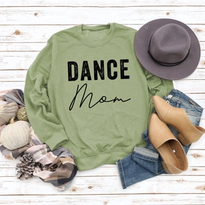 Detail of sage green sweatshirt featuring black DANCE Mom print and ribbed cuffs