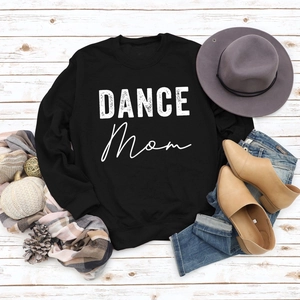 Flat lay of black DANCE MOM sweatshirt with ribbed collar on white wooden background