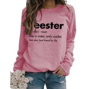 Close-up of pink crewneck sweatshirt with black Seester definition text and ribbed cuffs