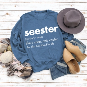 Blue crewneck sweatshirt with Seester print arranged with autumn accessories on wood