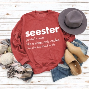 Flat lay of a burgundy crewneck sweatshirt with seester print and autumn accessories