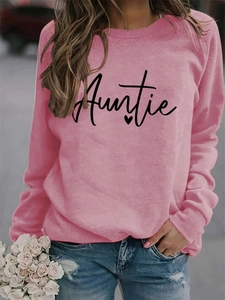 Close-up of the black Auntie script print and heart detail on a pink crewneck sweatshirt