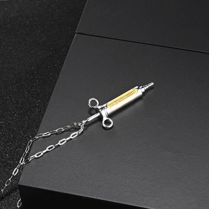 Hip hop style silver syringe pendant necklace with gold accents and curb chain link