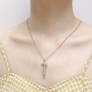 Hip-hop syringe pendant necklace in silver and gold titanium steel worn by a model