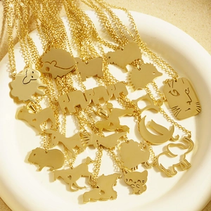 Süße goldene Tier-Anhänger-Halsketten im minimalistischen Stil auf einer Keramikplatte