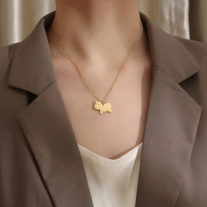 Nahaufnahme einer goldenen Wasserschwein-Halskette an einem Modell in braunem Blazer