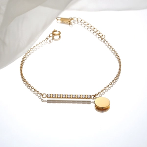 Gold stainless steel bracelet with zircon bar and round disc charm on mirror surface