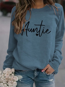 Detail of long sleeve misty blue sweatshirt featuring black Auntie text and heart print