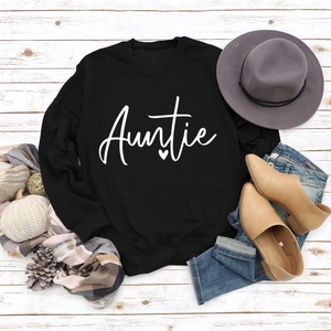 Flat lay of black long sleeve Auntie sweatshirt with autumn accessories on wood background