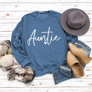 Flat lay of blue Auntie sweatshirt with autumn accessories on white wooden background