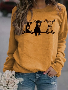 Détail d'un sweat à col rond jaune gingembre avec trois jolis imprimés de chèvres